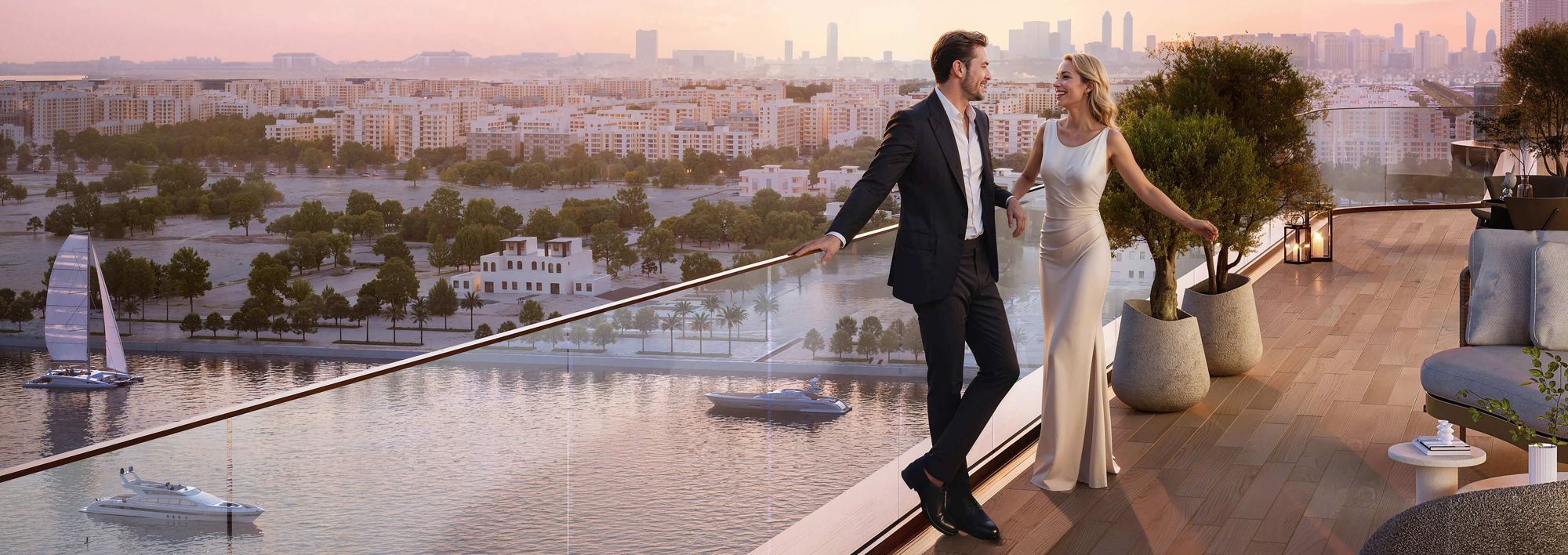 A couple on a Jumeirah Residences terrace overlooking the water and the Abu Dhabi skyline