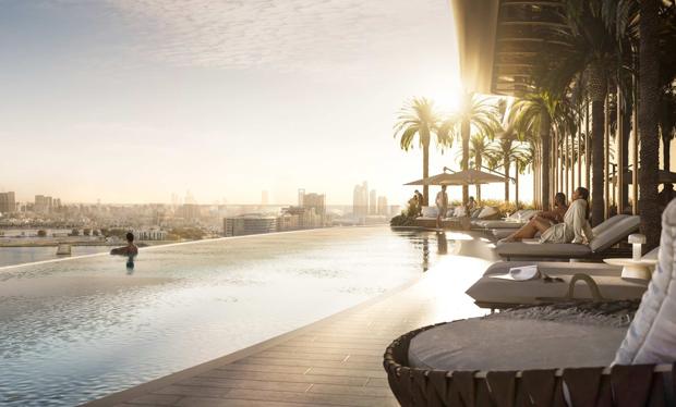 The elevated outdoor pool at sunset with loungers and palms