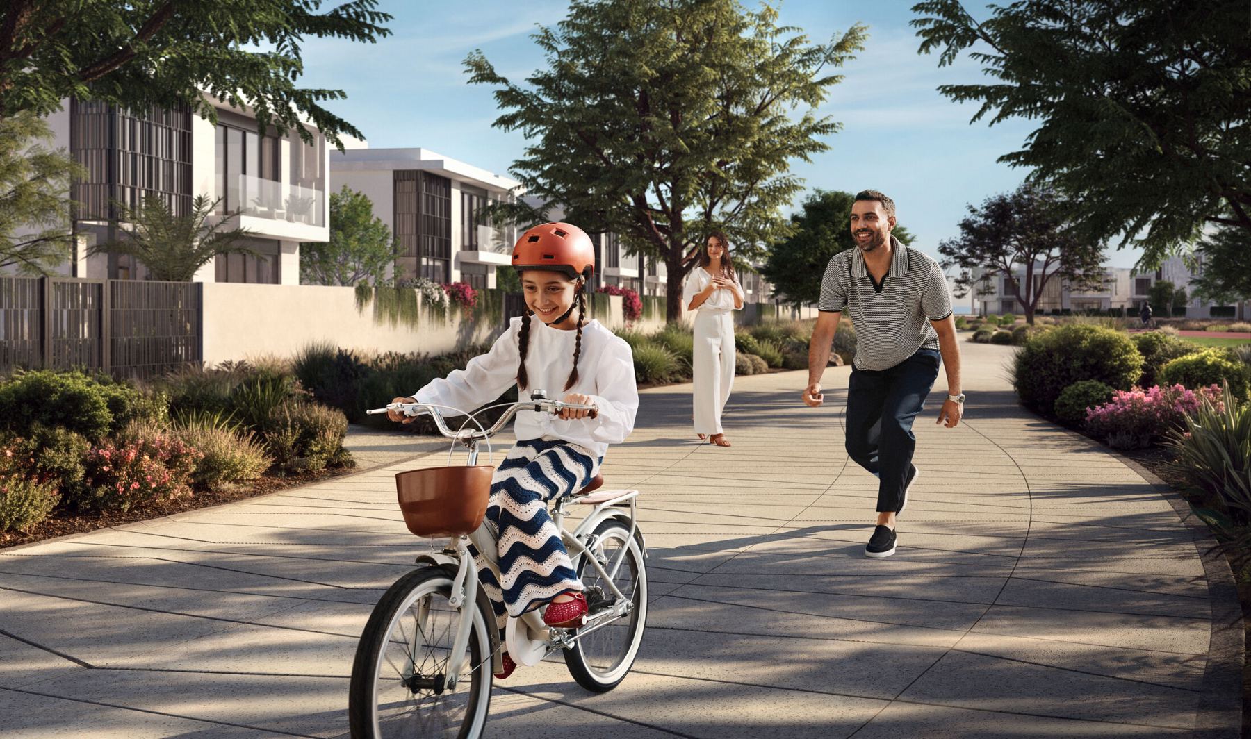 A father and daughter cycling along the green corridor at Marsa Al Saadiyat
