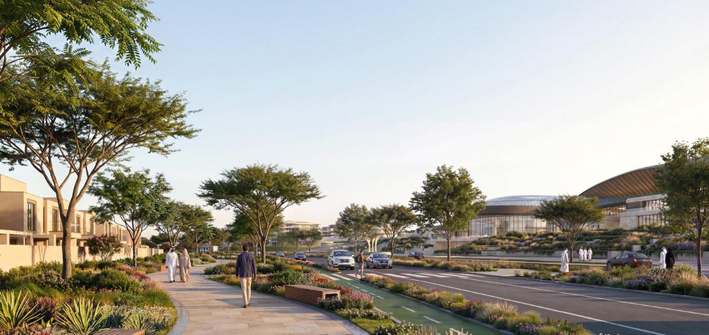 The Wadeem Gardens spine at Hudayriyat: a shaded walking route and cycle lane running past villas towards the arena and the retail district